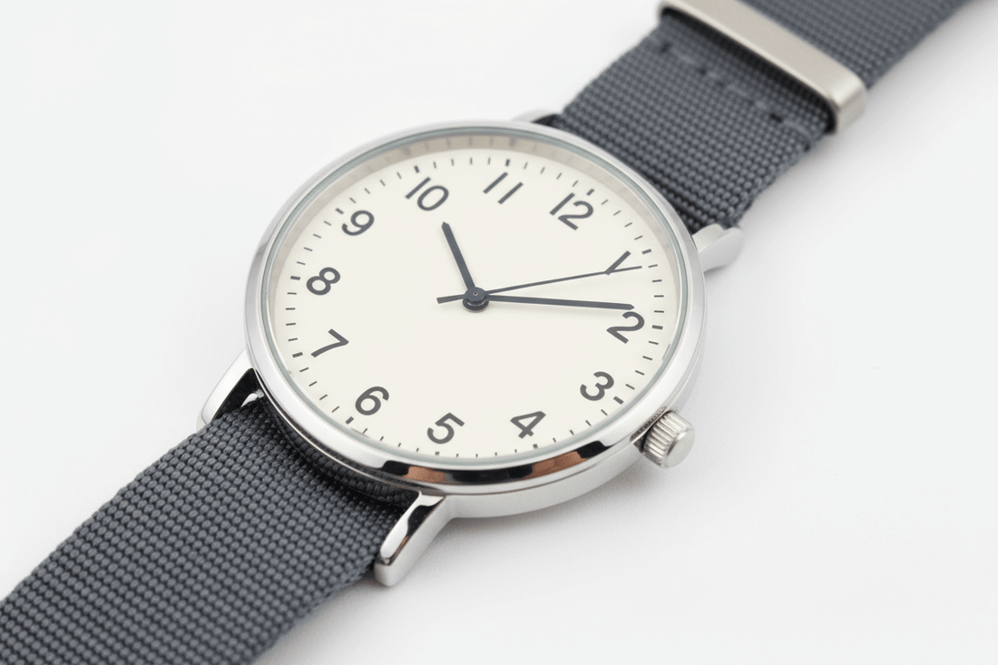 The Cost of Buying Cheap: The Downside to Discount Watches - Simple gray strap watch with numbers.