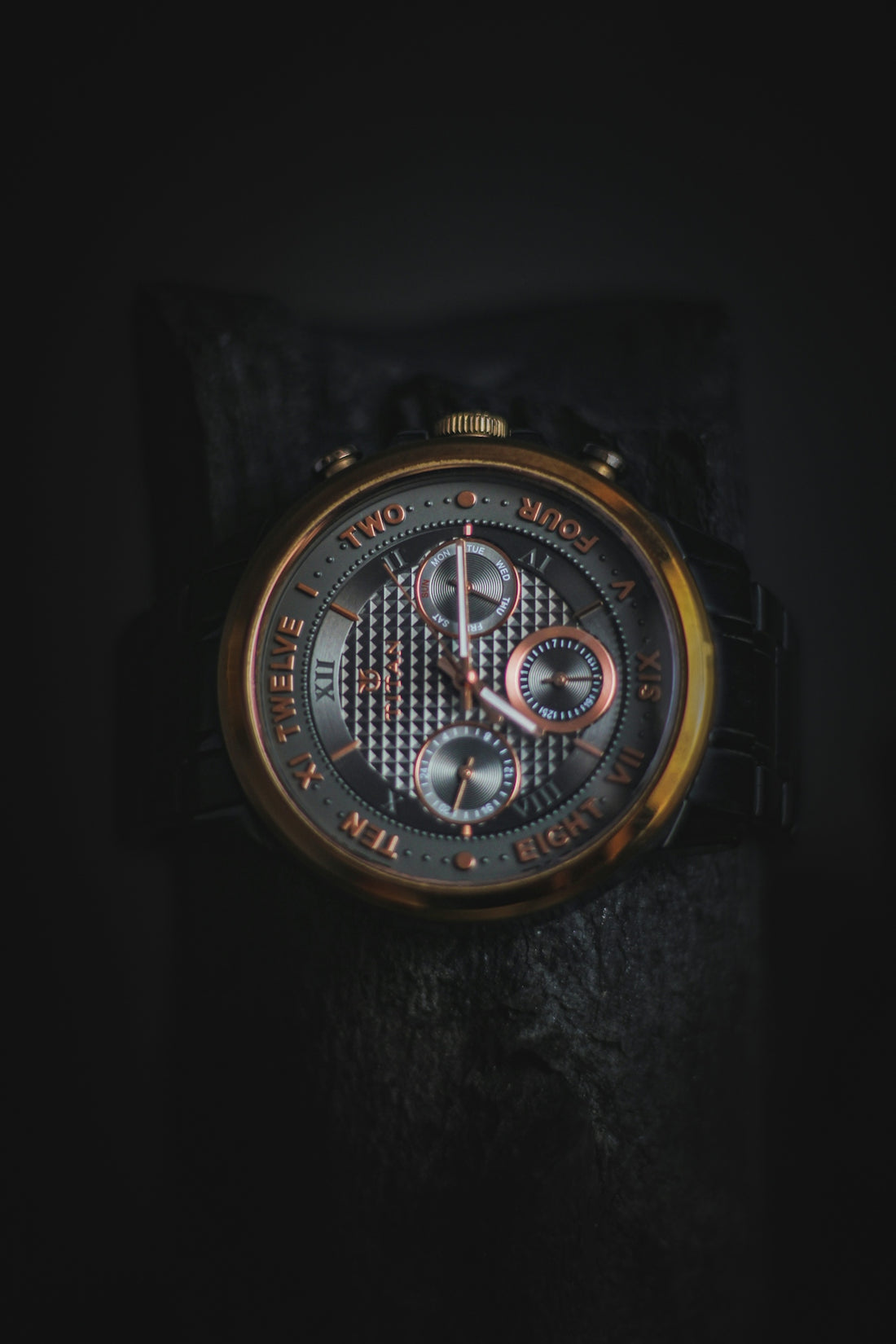 a close up of a watch on a black surface